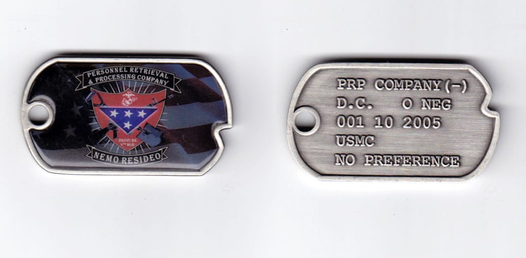 Dog tag shaped, pewter colored coin, 2-1/8 inches wide x  1-3/16 inches high.
