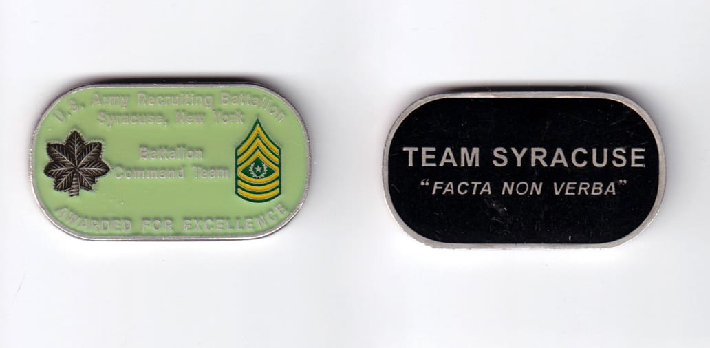 Dog tag shaped, silver colored coin, 2 inches wide x  1-1/16 inches high.