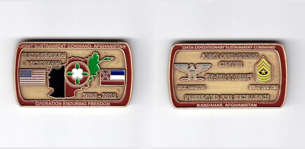 Retangular shaped, brass colored coin, 2 inches wide x  1-1/8 inches high.