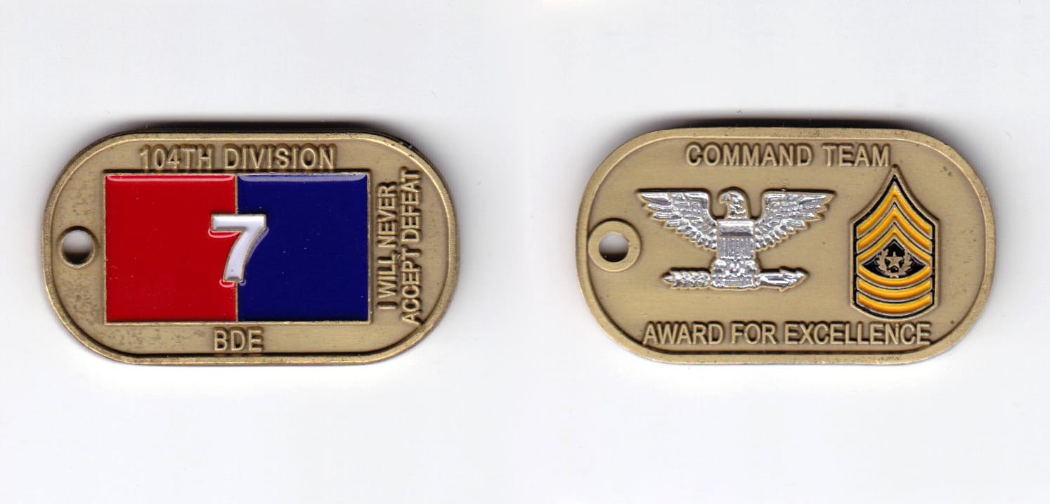 Dog tag shaped, brass colored coin, 2 inches wide x  1-1/8 inches high.