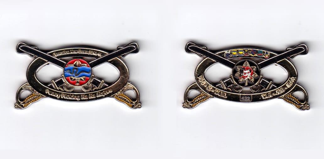 Oval shaped with crossed sabers extending, silver colored coin, 2-1/2 inches wide x  1-1/4 inches high.