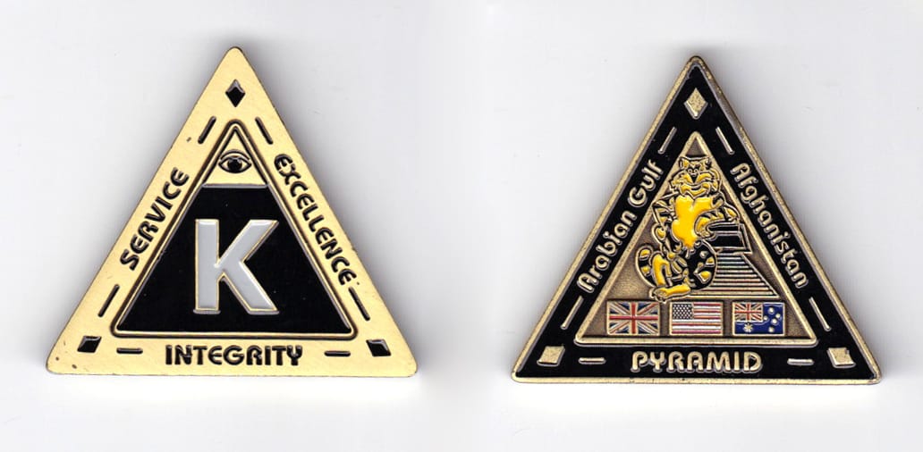 Triangular shaped, brass colored coin, 1-3/4 inches wide x  1-1/2 inches high.