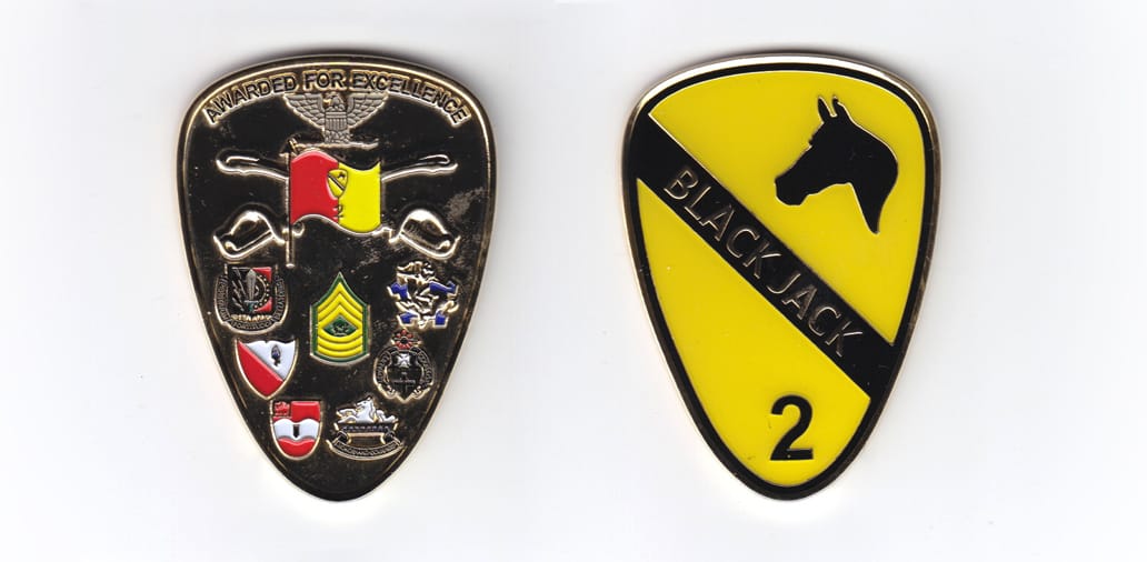 Shield shaped, gold colored coin, 1-5/8 inches wide x 2-1/2 inches high.