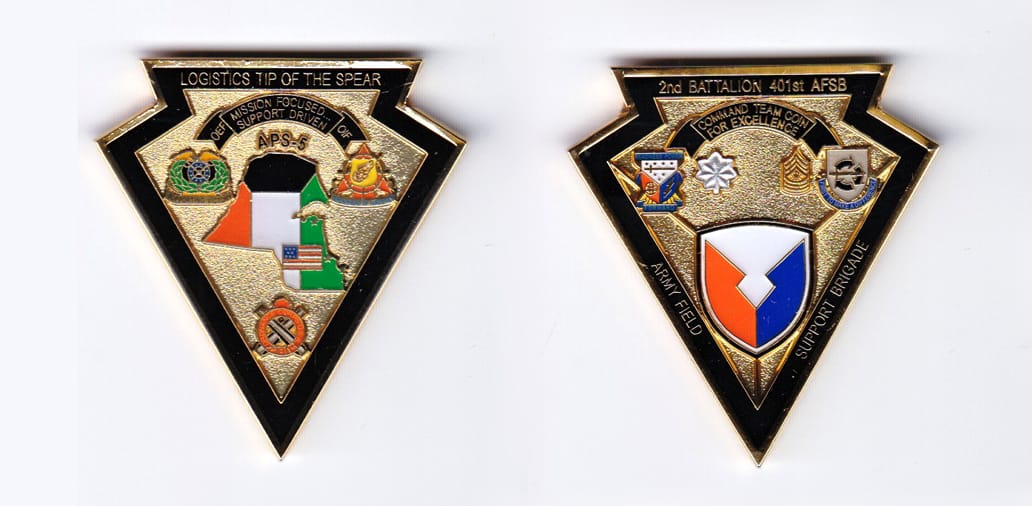 Spear point shaped, gold colored coin, 2 inches wide x 2-1/8 inches high.