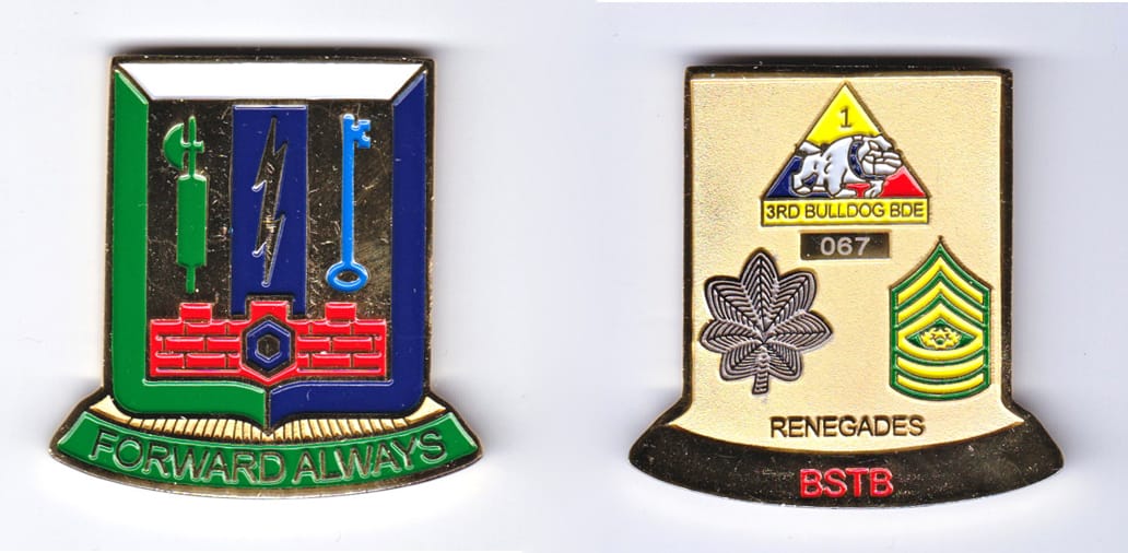 Shield shaped, with banner mounted beneath, gold colored coin, 1-1/2 inches wide x 2 inches high.