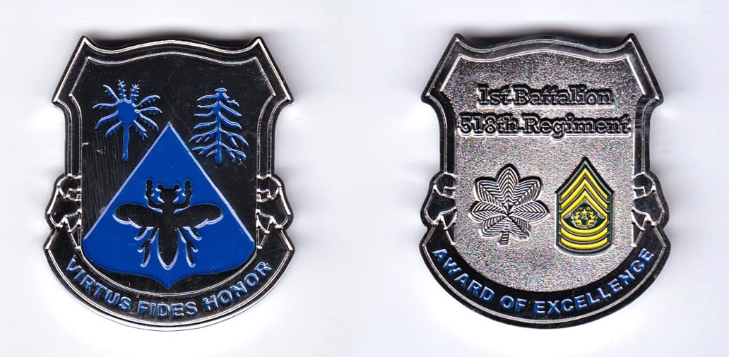 Shield shaped, with banner mounted beneath, silver colored coin, 1-1/2 inches wide x 2 inches high.