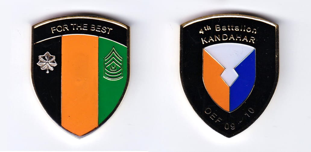 Shield shaped, gold colored coin, 1-1/2 inches wide x 1-3/4 inches high.