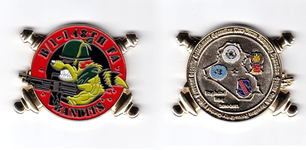 Circular shaped with crossed cannons extending, gold colored coin, 2-1/4 inches wide x 1-3/4 inches high.