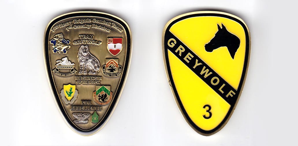 Shield shaped, silver colored coin, 1-3/4 inches wide x 2-1/2 inches high.