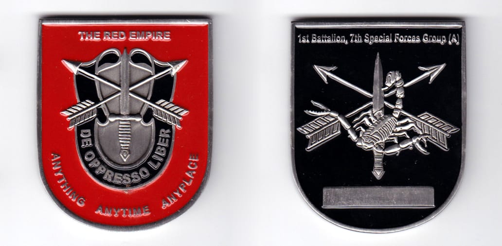 Shield shaped, pewter colored coin, 2 inches wide x 2-1/4 inches high.