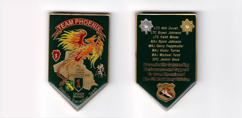 Shield shaped, brass colored coin, 1-1/2 inches wide x 2-3/8 inches high.