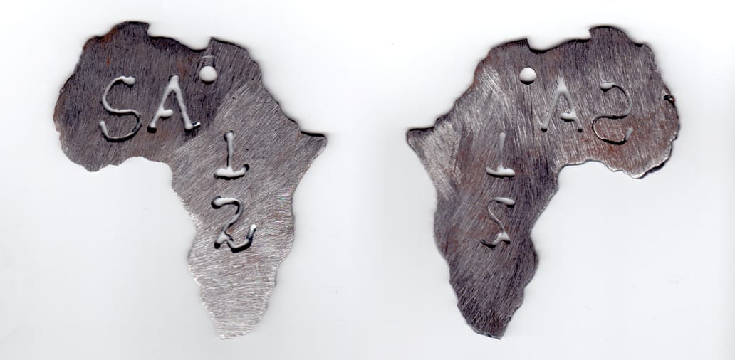 Africa shaped, brushed steel coin, 3 inches wide x 3-1/2 inches high.