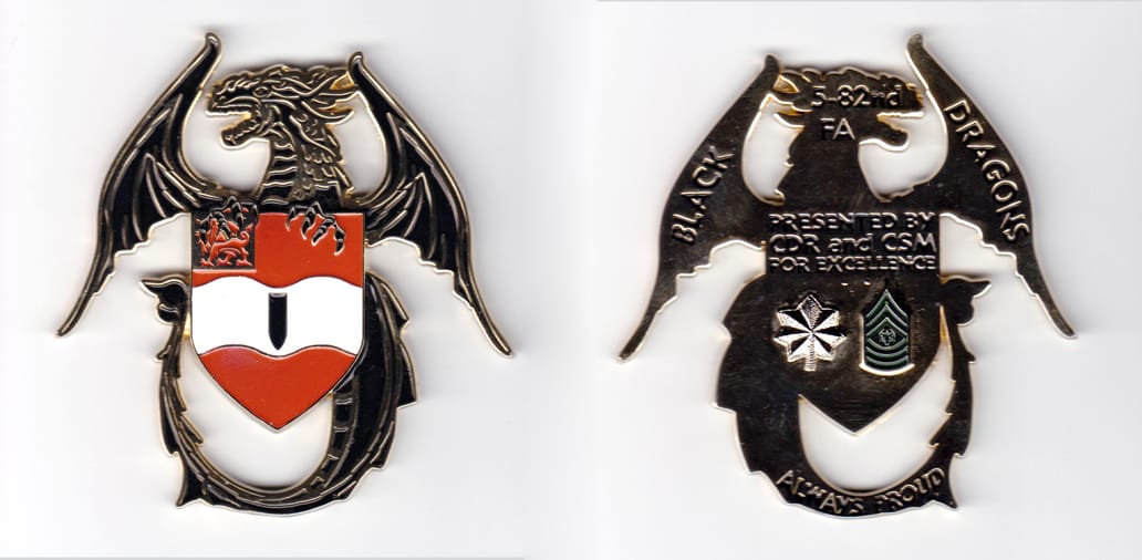 Shield shaped, with dragon surrounding, gold colored coin, 2-3/4 inches wide x 3 inches high.