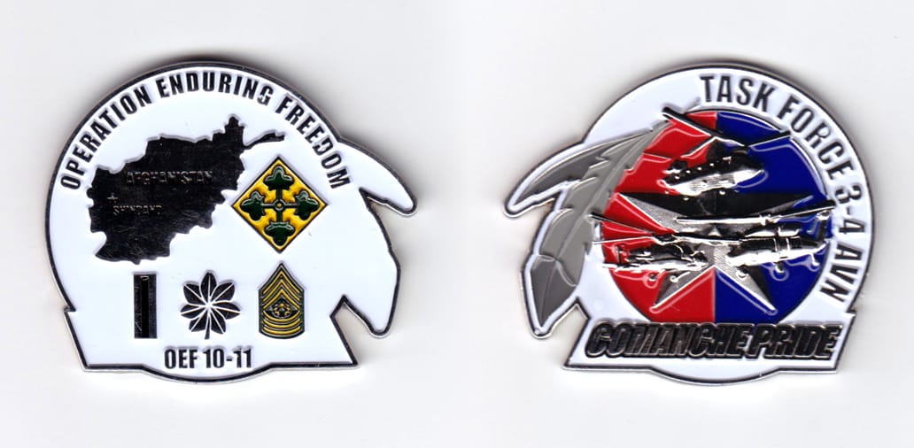 Circular shaped, with banner mounted and extending near base, and bird feathers extended from the side, silver colored c...