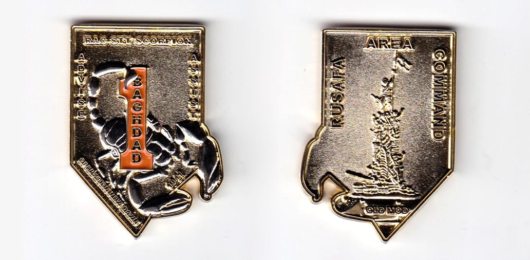 Shield shaped, with scorpion claws extended lower right, gold colored coin, 2 inches  high x 1-1/2  inches wide.