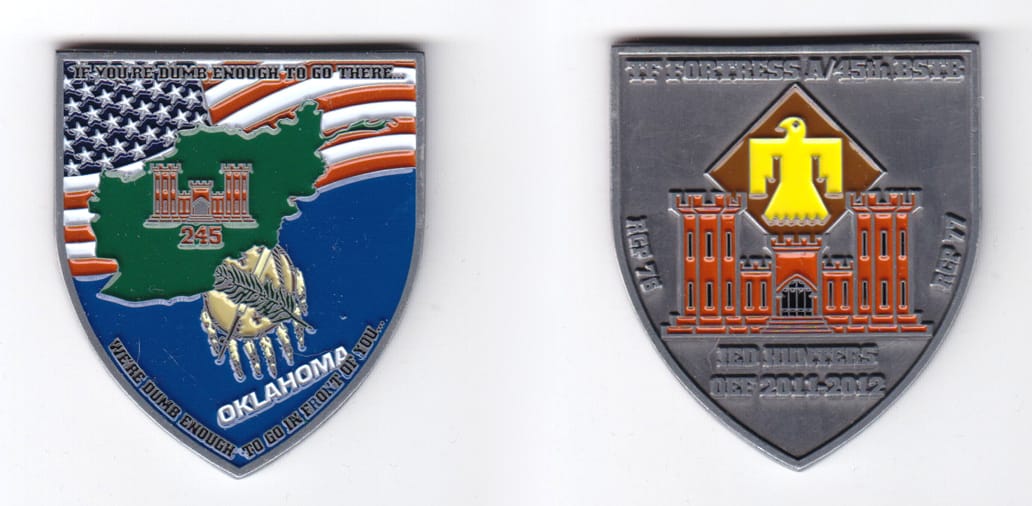 Shield shaped, silver colored coin, 2 inches high x 1-49/64  inches wide.