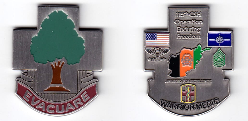 Cross shaped with banner beneath, pewter colored coin, 2 inches high x 1-41/64  inches wide.