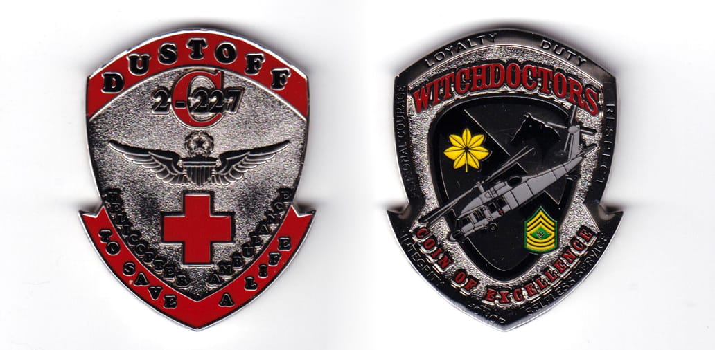 Shield shaped, silver colored coin, 2 inches high x 1-39/64  inches wide.