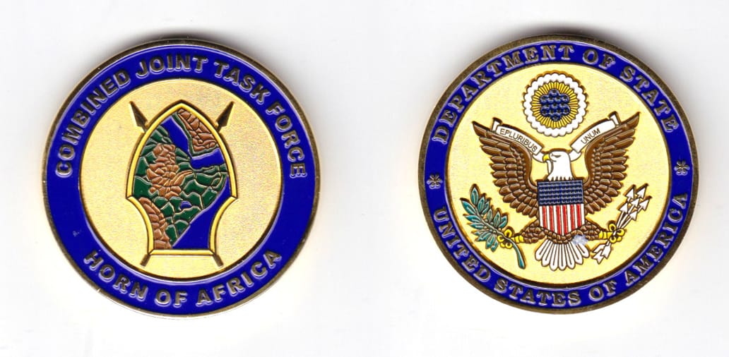 round shaped coin, brass in color, 1 3/4 inches in diameter.