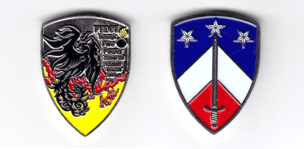 Shield shaped coin, silver in color, 1 1/2 inches high x 1 9/64 inches wide.