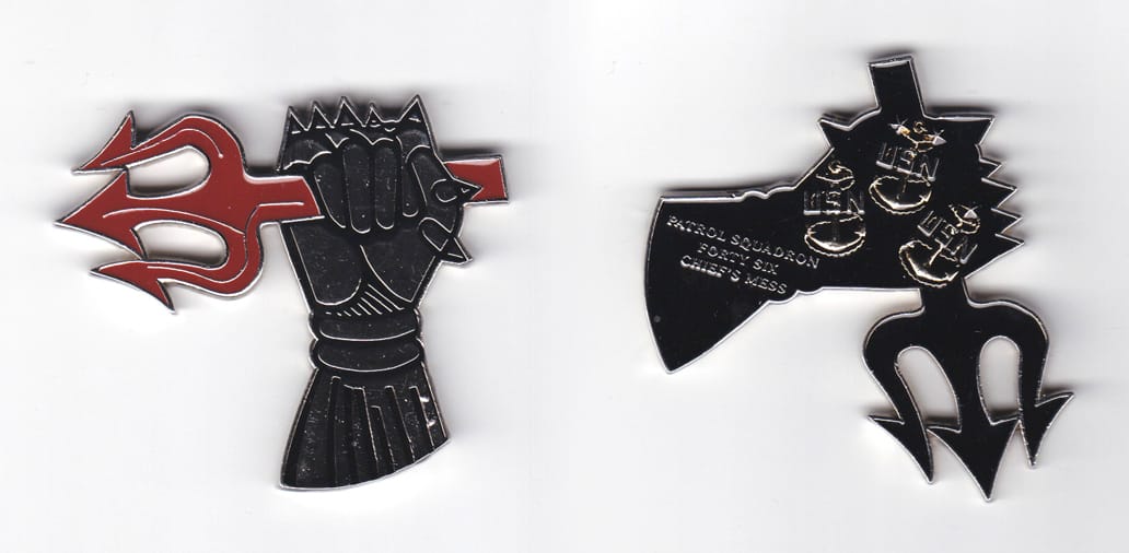 A black gauntlet clutching a red barbed trident, with silver edges,     2 7/64 inches high x 2 15/32 inches wide.
