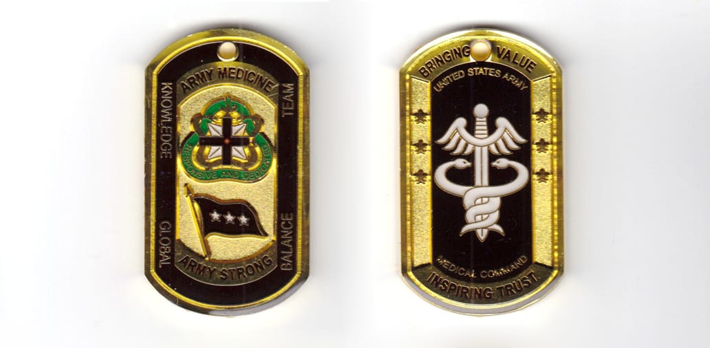 Dog tag shaped coin, brass in color, 2 11/64 inches high x 1 17/64 inches wide.