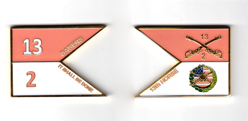 Guidon shaped coin, brass in color, 1 53/64 inches high x 2 1/2 inches wide.