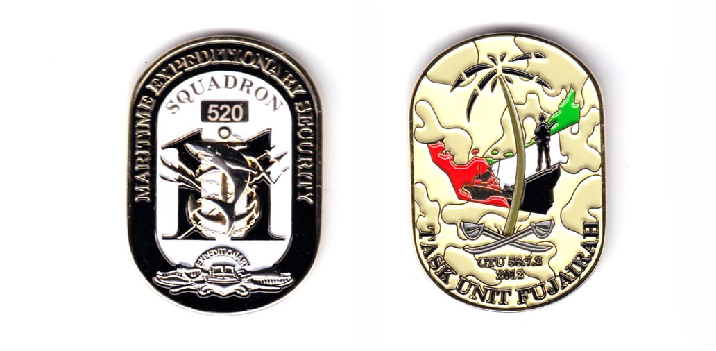 Dog tag shaped coin, gold in color, 1 63/64 inches high x 1 13/32 inches wide.