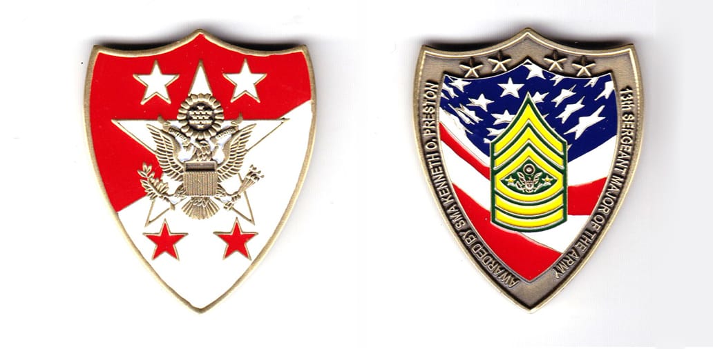 Shield shaped coin, brass in color, 1 7/8th inches high x 1 17/32 inches wide.