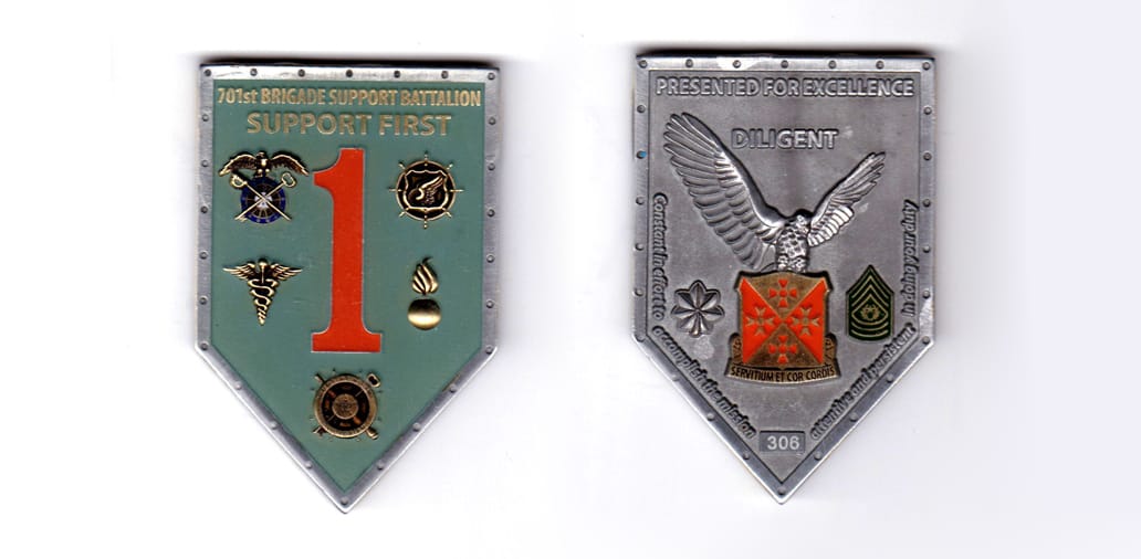 Shield shaped coin, antique pewter in color, 2 33/64 inches high x    1 45/64 inches wide.