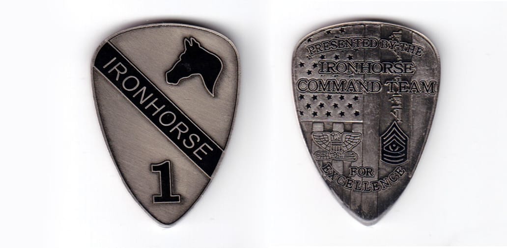Shield shaped coin, pewter in color, 2 inches high x 1 31/64 inches wide.