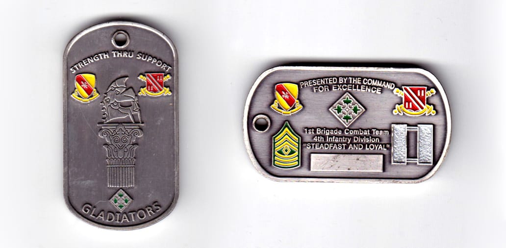 Dog tag shaped coin, pewter in color, 1 63/64 inches high x 1 3/32 inches wide.