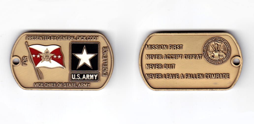 Dog tag shaped coin, antique brass in color, 1 inch high x 2 1/4 inches wide.