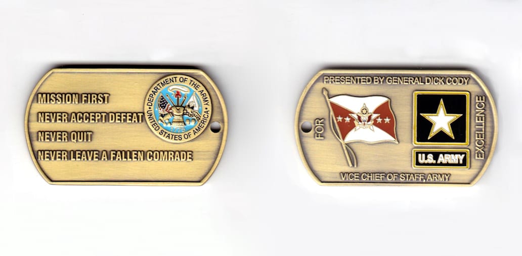 Dog tag shaped coin, antique brass in color, 1 inch high x 2 1/4 inches wide.