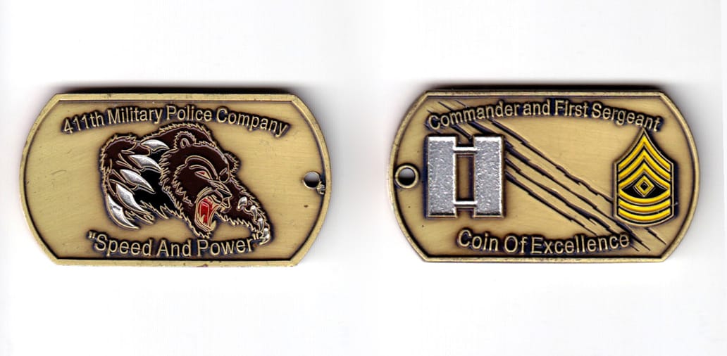 Dog tag shaped coin, antique brass in color, 1 13/64 inches high x   2 5/32 inches wide.