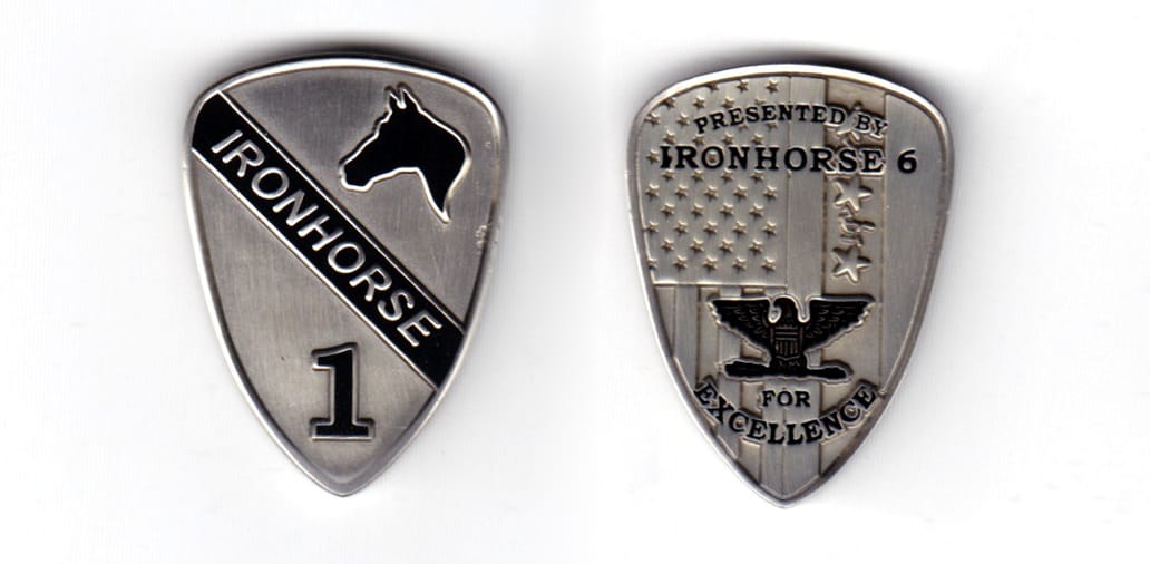 Sield shaped coin, pewter in color, 1 1/2 inches high x 1 7/64 inches wide.