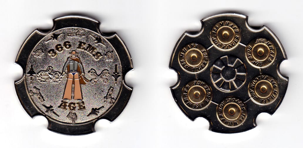 Round shaped coin with 6 round indentations spaced evenly around the perimeter, pewter in color, 2 inches in diameter.