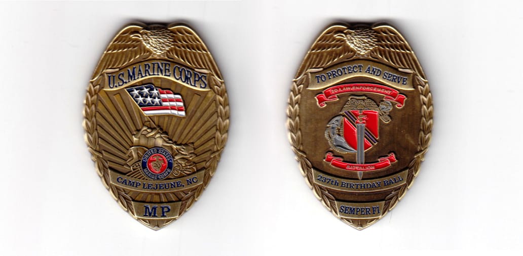 Badge shaped coin, antique brass in color, 2 19/64 inches high x 1 5/8 inches wide.