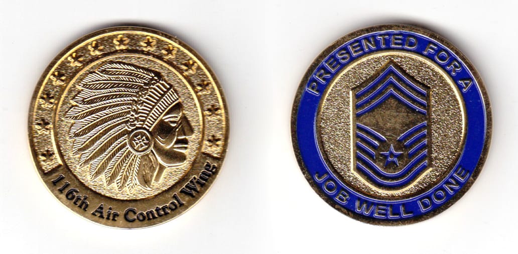 Round shaped coin, brass in color, 1 33/64 inches in diameter.