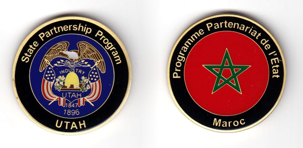 Round shaped coin, brass in color, 1 25/64 inches in diameter.