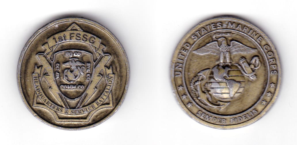 Round shaped coin, gunmetal black in color, 1 13/32 inches in diameter.