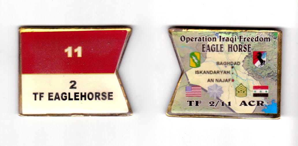 Swallowtail flag shaped coin, antique brass in color, 1 35/64 inches high x 1 63/64 inches wide.