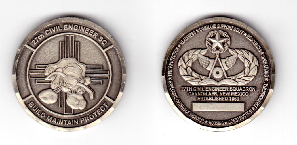 Round shaped coin, gunmetal black in color, 1 1/2 inches in diameter.