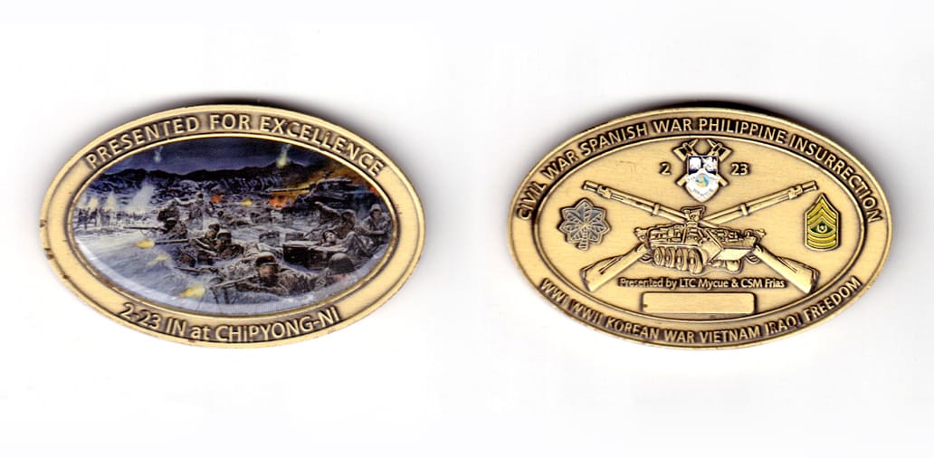 Oval shaped coin, brass in color, 1 31/64 inches high x 2 23/64 inches wide.