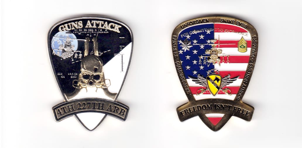 Shield shaped coin with banner in front and extending beyond, brass in color, 2  1/2 inches high x 1 7/8 inches wide.