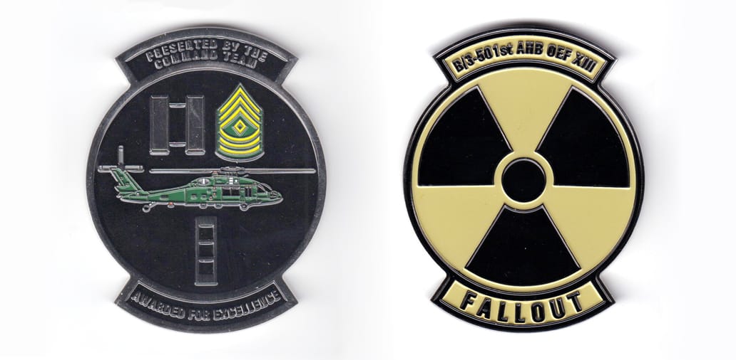 Round shaped coin with banner both above and below, silver in color, 3 inches high x 2 3/8 inches wide.