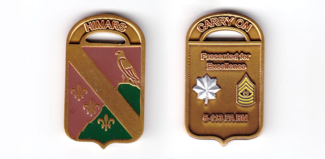 Shield shaped coin with arched banner over, copper in color, 1 49/64 inches high x 1 3/64 inches wide.