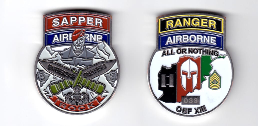 Round shaped coin with banners above, silver in color, 2 1/64 inches high x 1 43/64 inches wide.