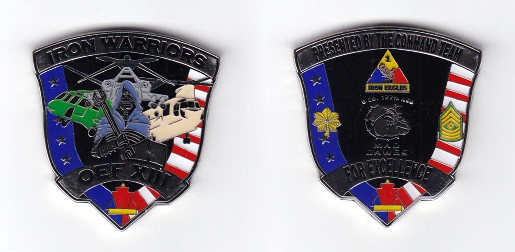 Shield shaped coin with banner wrapped around the bottom, pewter in color, 2 1/64 inches high x 1 29/32 inches wide.