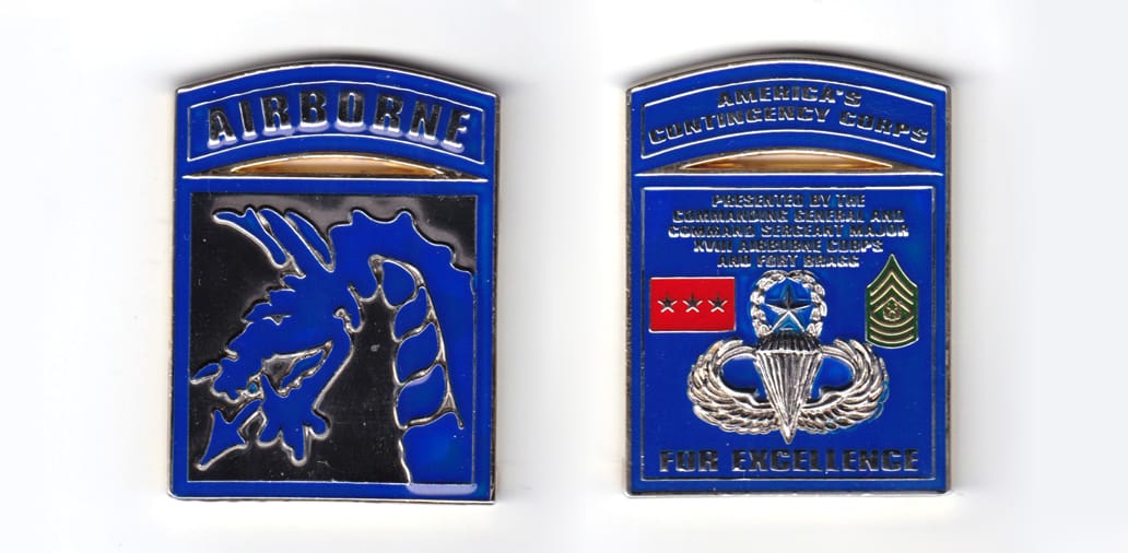 Square shaped coin with bowed banner over, brass in color, 2 1/2 inches high x 1 3/4 inches wide.